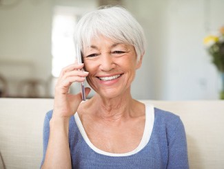 Senior woman sitting on couch talking on phone