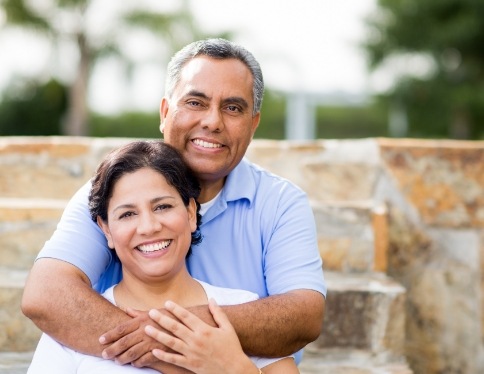 Man and woman with healthy smiles after dental crown restoration