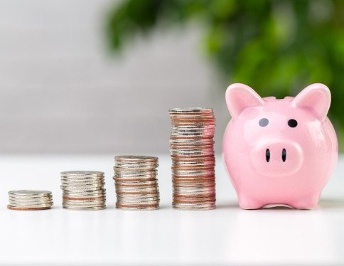 Pile of coins next to a piggy bank