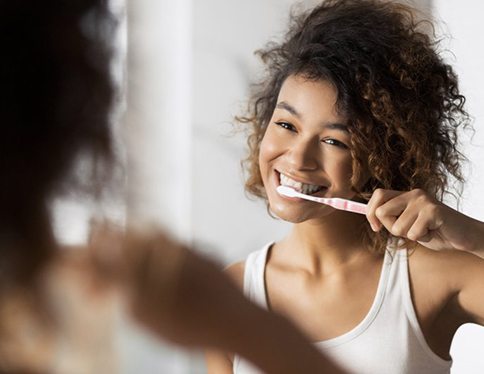 Woman brushing her whitened teeth