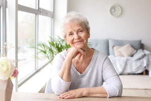 Senior woman sitting at table and smiling